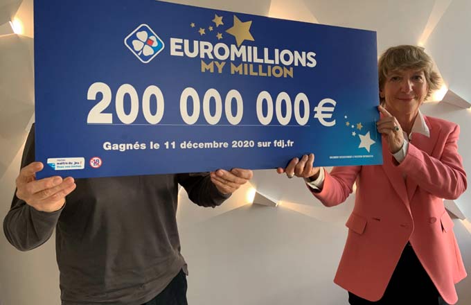 Remise du chèque de 200 millions d’euros, remporté en décembre 2020, avec le gagnant qui se cache derrière le chèque, et Stéphane Pallez, PDG de la Française des Jeux (crédit photo: FDJ)