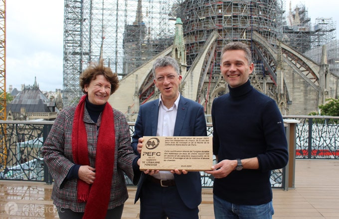 Sur le chantier de Notre-Dame, remise de la certification de projet PEFC par Christine de Neuville, présidente de PEFC France (à gauche). Au centre, Philippe Jost, président de Rebâtir Notre-Dame de Paris. À droite, Rémi Fromont, architecte en chef des monuments historiques (crédit photo : CC/Forestopic)