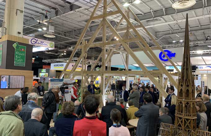 Maquette en chêne de deux fermes de la charpente de Notre-Dame, présentée au salon des maires 2019 par France Bois Forêt et réalisée par des apprentis charpentiers des Compagnons du devoir à l’échelle 3/4. Au premier plan à droite, maquette en noyer de la flèche de Notre-Dame (crédit photo: Philippe Dupuy)